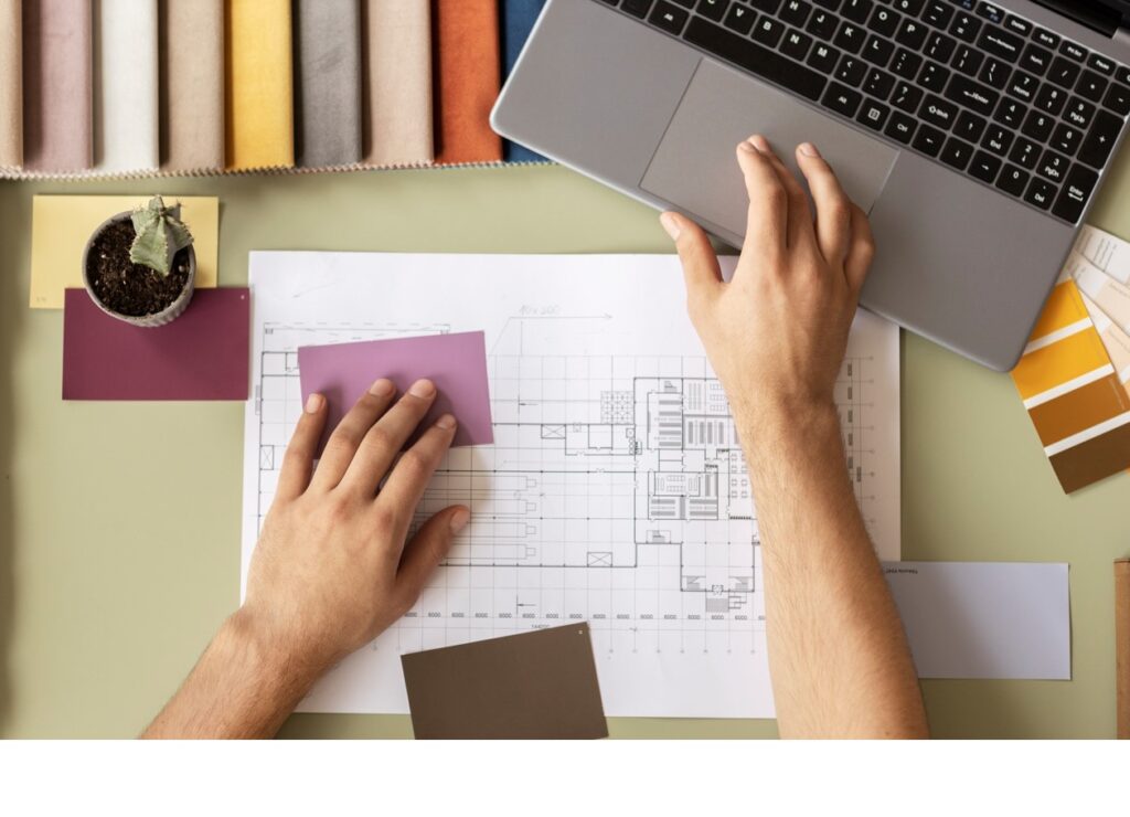 Manos de una persona escogiendo materiales y diseñando un proyecto de interiorismo.