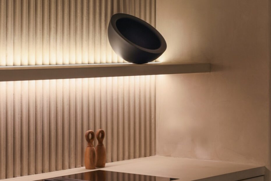 Estantería iluminada con una tira led y 3 elementos de diseño. La pared tiene textura. Integra Estudio de interiores