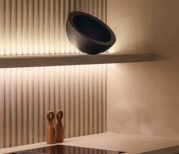 Estantería iluminada con una tira led y 3 elementos de diseño. La pared tiene textura. Integra Estudio de interiores