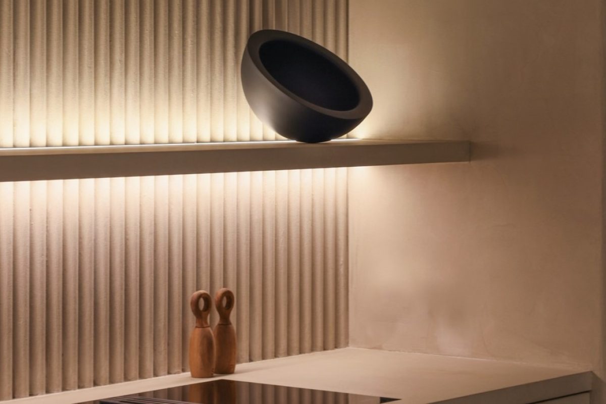 Estantería iluminada con una tira led y 3 elementos de diseño. La pared tiene textura. Integra Estudio de interiores